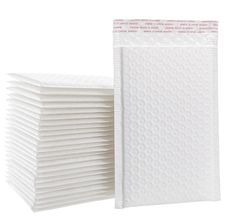 a stack of white napkins sitting next to each other on top of a white surface