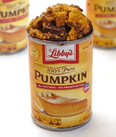 there is a can of pumpkin cake in the middle of three other cans behind it