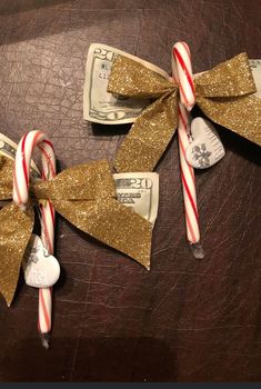 two candy canes tied together with bows and money