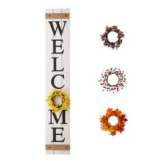 three wreaths are hanging next to a welcome sign