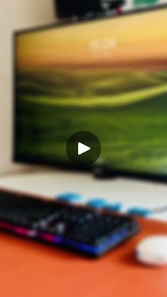 a flat screen tv sitting on top of a wooden table next to a keyboard and mouse