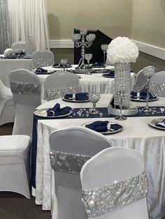 a banquet room set up with white and blue linens, silver sequin tablecloths and crystal centerpieces