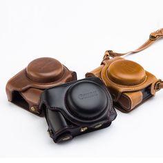 three leather camera cases sitting next to each other