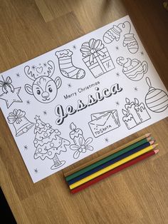 a christmas coloring page with colored pencils and markers on the table next to it