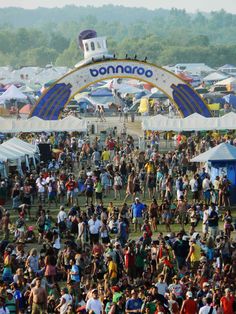 a large group of people standing in front of tents