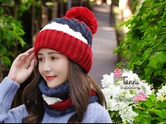 a young woman wearing a red, white and blue knitted hat with pom - pom