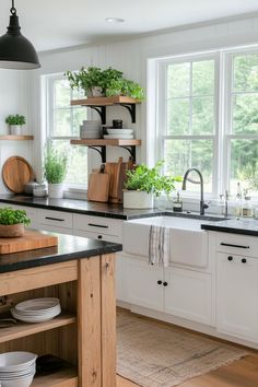 a kitchen filled with lots of counter space and wooden shelves next to a white sink