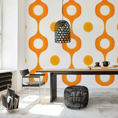 an orange and white wallpaper in a dining room with modern chairs, table and lamp