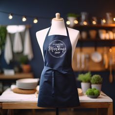 an apron on a mannequin in front of a table with potted plants