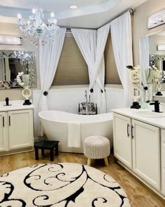 a white bathroom with a tub, sink and chandelier hanging from the ceiling