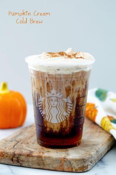 a cup of pumpkin cream cold brew sitting on top of a cutting board