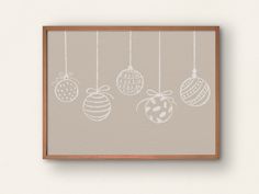 an image of christmas ornaments hanging from strings on the wall in front of a white wall