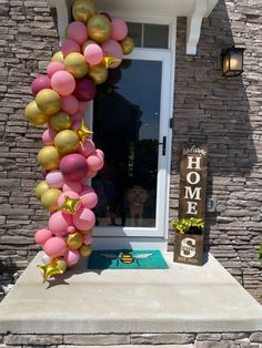 a house decorated with balloons and streamers in front of the door to welcome home