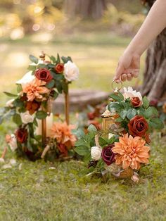 the bride is placing her wedding ring on the flower arrangement in front of the tree