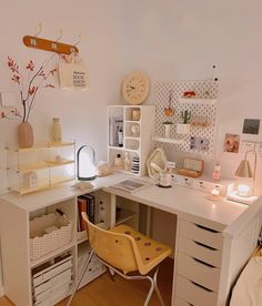 a white desk topped with lots of drawers next to a wall filled with pictures and other items