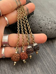 This unique earrings are made with a brass chain and unique Rudraksha beads from Nepal. One style is Rudraksha beads with metal work and the other one is plain Rudraksha beads. In one of the pictures you can see which style represents each pair. A unique pair that will be perfect for your day by day outfits do to its beautiful earth tones and look. They are super light what makes them easy to wear. The earrings are 8.7cm- 3.5 inch long The drop length of the earrings are 10cm- 4 inch A most have Brass Earrings With Adjustable Chain For Gift, Bronze Dangle Plug Earrings Nickel Free, Nickel-free Bronze Dangle Plug Earrings, Spiritual Bronze Dangle Earrings, Spiritual Brass Dangle Earrings, Spiritual Dangle Plug Earrings As Gift, Spiritual Metal Plug Earrings As Gift, Spiritual Latkans Earrings For Gift, Artsy Earrings