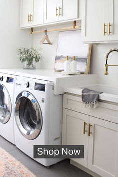 white laundry room with two bottles of soap bottle dispensers and a sponge on a marble tray