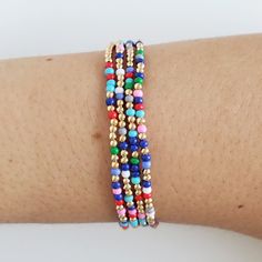 a close up of a person's arm wearing bracelets with beads on it