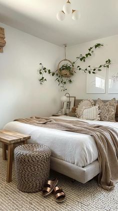 a bedroom with a large bed and plants on the wall