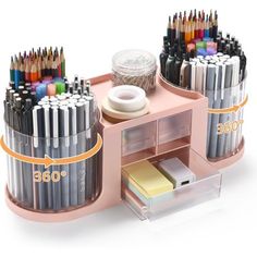 an assortment of pens and pencils on a pink desk with clear storage bins