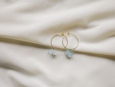 The way the light blue compliments the gold, the simplicity of the two aquamarine gemstones, and the minimalistic feel from the hoops make these earrings the perfect everyday hoops adding a delicate touch of color.  D E T A I L S - 18k gold plated 20 mm hoop.  - Two beautiful aquamarine gemstones. Each gemstone is unique and will vary in size, shape, and color.  - Earring hook is gentle on the ears and feels secure.  - Comfortable and light to wear.  ∙ EXTRAS  - Handcrafted with a lot of love.   - All of my jewelry arrives tightly wrapped.  - If this is a special gift or if you would like a customization just let me know in the message box at checkout.  ∙ MY SHOP Check out more of my pieces - https://www.etsy.com/shop/ashlikitta?ref=simple-shop-header-name&listing_id=1384487927 ∙ FIND ME O Blue Dainty Hoop Jewelry, Elegant Blue Small Hoop Jewelry, Blue And Gold Earrings, Handmade Small Hoop Blue Earrings, Blue Handmade Minimalist Hoop Earrings, Aquamarine Hoop Earrings, Aquamarine Gemstone, Aquamarine Blue, Aquamarine