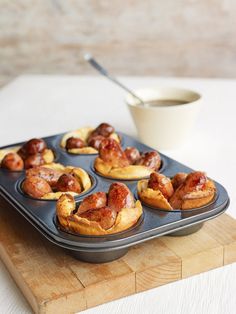 mini pigs in a blanket sitting on top of a baking tray next to a cup of coffee