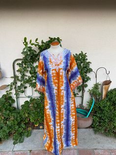 "Vintage 1970's caftan style dress in a great orange and blue print.  V-neckline with angel sleeves.  White embroidery around the neckline and the sleeves.  Great vintage condition.  There is a small hole near the front hem.  See last pic.  It appears the original hem was let down and this may have happened in the process.  It could be hemmed back up or patched easily. label:  Mice fabric:  cotton size:  not readable.  Size small to medium to large is just an estimate depending on desired fit. Spring Bohemian Kaftan With Batik Print, Orange Long Sleeve Kaftan For Spring, Blue Hippie Kaftan For Spring, Long Sleeve Orange Kaftan For Spring, Orange Cotton Bohemian Maxi Dress, Orange Bohemian Cotton Maxi Dress, Spring Bohemian Batik Print Kaftan, Bohemian Orange Dresses With Kimono Sleeves, Bohemian Orange Cotton Maxi Dress