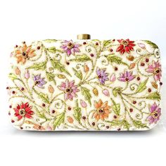 "Beautiful designer luxury ivory white velvet hard case clutch bag, hand embroidered with vibrant and cheerful multicolor flowers and embellished with ruby gemstones. Each delicate leaf and flower petal is outlined with glittery metallic thread, to add sparkle and bling to your look. This will be your go to purse for any wedding! A classic design that never goes out of style. Expertly hand embroidered by third generation zardozi artisans. The word Zardozi means \"gold thread\". It is a centuries White Embroidered Rectangular Evening Bag, Designer White Evening Bag As Gift, Designer White Evening Bag For Gift, White Embroidered Evening Bag For Reception, White Embroidered Clutch For Receptions, White Embroidered Clutch For Reception, White Clutch For Wedding And Festivals, Embroidered Cream Rectangular Clutch, Embroidered Cream Clutch Evening Bag