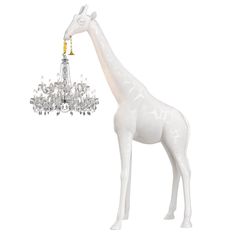 a white giraffe standing next to a chandelier