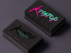 two black business cards with pink and green ink on them, one has the word xyron printed on it