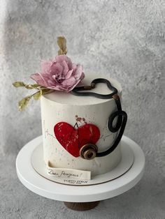 a decorated cake with a stethoscope and heart on the top is sitting on a stand