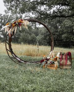 an outdoor ceremony setup with flowers and feathers on the grass in front of a tree