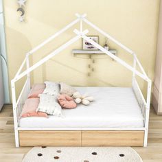 a small white bed sitting on top of a wooden floor