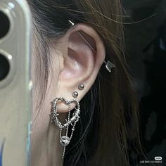 a woman with ear piercings on her ears and behind the ear is a mirror