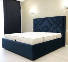 a bed with a blue upholstered headboard and foot board in a room