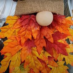 an egg sitting on top of a burlock surrounded by autumn leaves and eggshells