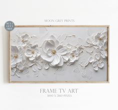 the frame tv art is shown with white flowers and gold leaves on it's side