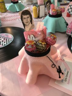 a pink stuffed animal with candy and candies in it's mouth on top of a table