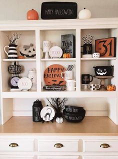 a white bookcase filled with lots of halloween decorations on top of a wooden table