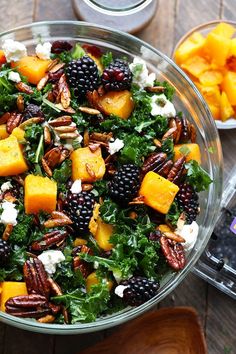 a glass bowl filled with fruit and nuts on top of a wooden table