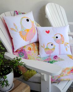 two pillows sitting on top of a white chair