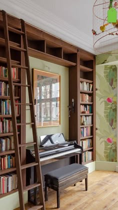 a room with bookshelves and a piano in the corner, next to a ladder