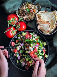 a person is cutting up vegetables in a bowl next to other foods on the table