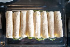 there are many sandwiches on the tray ready to be cooked in the oven or put into the oven