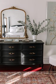 a black dresser and mirror in a room