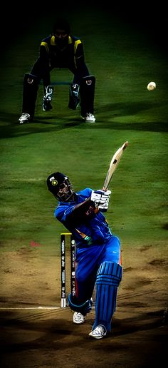 a man swinging a bat at a ball in a game of cricket on a field