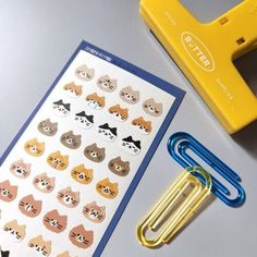 an assortment of cat stickers next to a yellow stapler and clippings