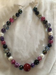 Handmade beaded choker with white skull bead, purple, pink , grey and clear iridescent beads. Iridescent Adjustable Necklace With Round Beads, Iridescent Adjustable Round Bead Necklaces, Purple Beaded Choker With Round Beads, Purple Colorful Beads Choker Jewelry, Purple Colorful Beaded Choker Jewelry, Adjustable Purple Choker With Colorful Beads, Adjustable Purple Choker With Round Beads, Beaded Skull, Choker Necklaces