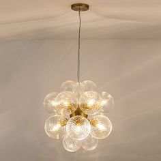 a chandelier hanging from the ceiling in a room with white walls and flooring