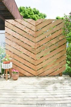 a wooden structure sitting on top of a wooden deck next to a potted plant